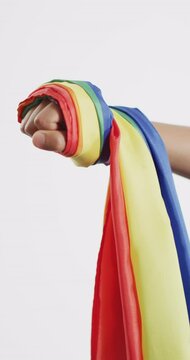 Vertical video of hand of caucasian man holding rainbow fabric