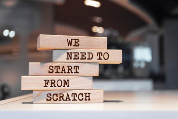 Wooden blocks with words 'We need to start from scratch'.