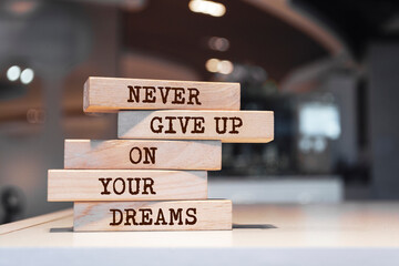 Wooden blocks with words 'Never give up on your dreams'.