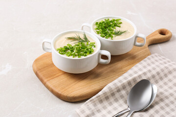 Bowls with tasty creamy soup of parsnip served on light grey background