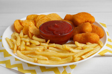Tasty french fries, chicken nuggets, chips and ketchup on white wooden table, closeup