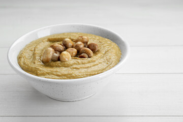 Delicious mushroom cream soup on white wooden table. Space for text