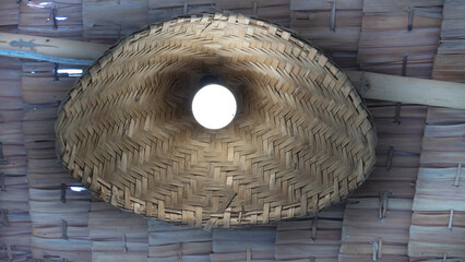 Round lamp with woven bamboo as a lantern. under a roof made of bamboo.