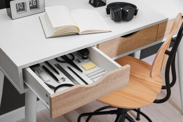 Office supplies in open desk drawer indoors