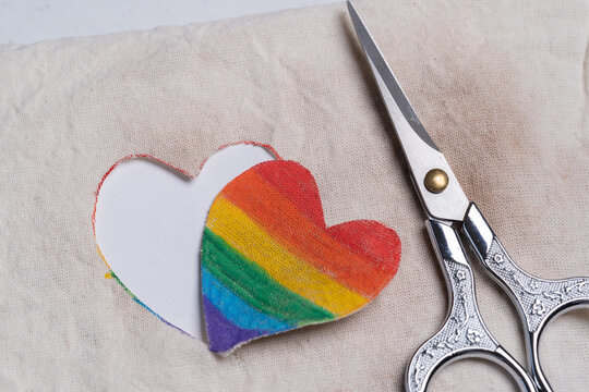 corazón pintado a mano con colores de bandera del orgullo gay, recortado y tijeras a un lado