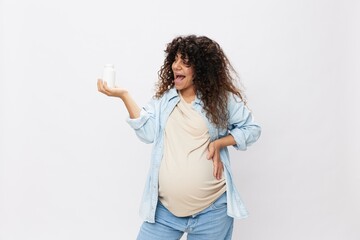 Pregnant woman smile with teeth a jar of pregnancy vitamin pills in her hands, alpha lipoic acid, vitamin complex on a white isolated background