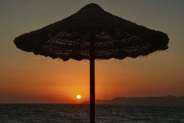 Sombrilla al atardecer con puesta de sol