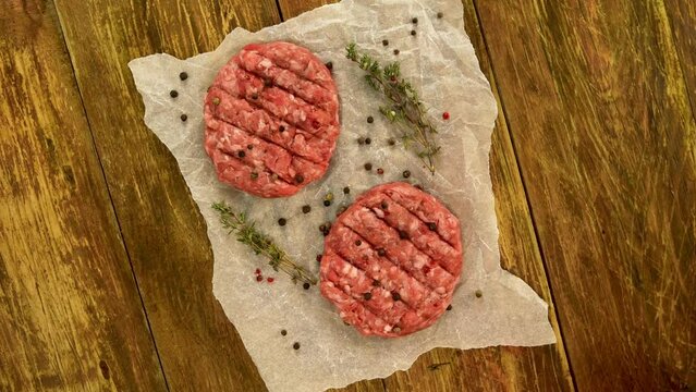 Raw meat burger cutlets, with spices and thyme.
