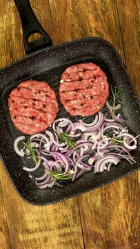 Raw meat burger cutlets, with spices, sliced onion