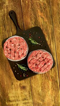 Raw meat burger cutlets, with spices and rosemary.