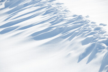 Abstract shadow and light patterns in white winter snow background