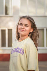 Portrait of a young beautiful girl in jeans and a T-shirt in a summer park.