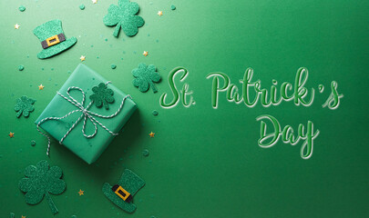 Happy St Patrick's Day decoration concept made from shamrocks ( clover leaf), gift box and leprechaun hat on green background.