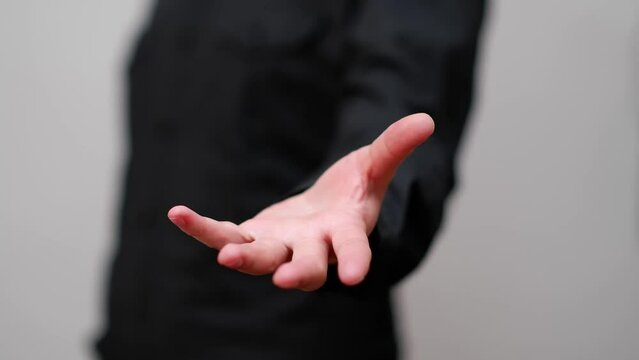 man in black clothes opens and closes his hand as a gesture of releasing or receiving something, white background, usable for technology