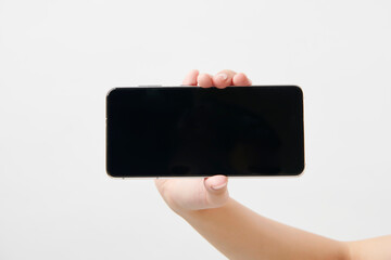 가로로 휴대폰을 들고 있는 여성의 손