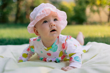 Baby girl in outdoor garden on the lawn.