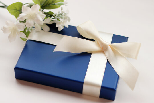 白いリボンで巻かれた青いギフトボックスのプレゼントイメージ	
