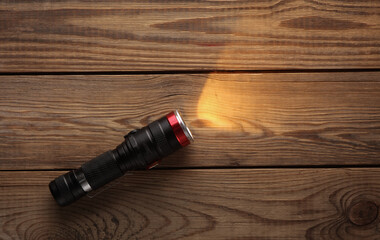 Included bright flashlight on a wooden table