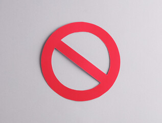 Red prohibition sign cut out of paper on a gray background