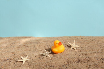 Fototapeta na wymiar Rubber duck on the sand. Beach holiday, summer time