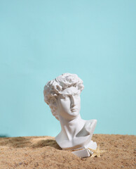 Gypsum bust of David in the sand. Beach holiday