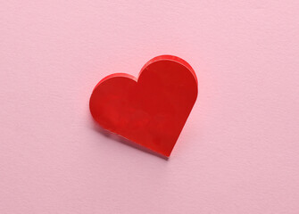 Red paper heart shaped valentine on pink background