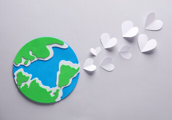 Planet earth with heart on gray background. Love concept