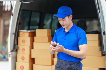 Delivery man asia people checking portable delivery device with parcel box to customer home address. typing message, using mobile smartphone
