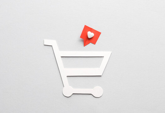 Paper-cut shopping trolley with Social media like on gray background