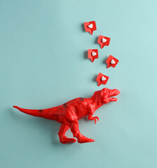 Plastic tyrannosaurus rex with Social media likes on blue background. Creative minimal layout