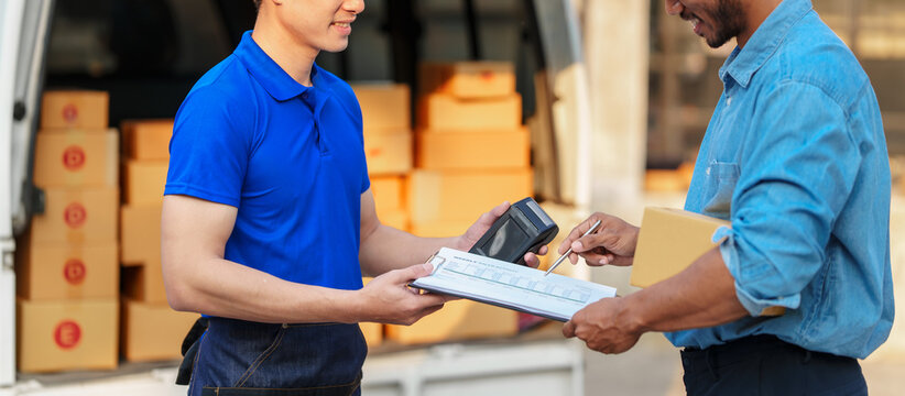 Delivery man asia people checking portable delivery device with parcel box to customer home address. give delivery box to customer and sign a signature of receiver people