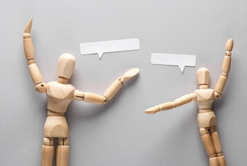 Discussion. Two puppets with a speech bubble on a gray background