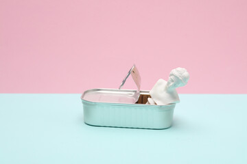 Open tin can with Venus bust on pink blue background. Creative layout