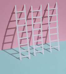 Paper ladders on a blue-pink pastel background. Creative layout, business, career growth concept