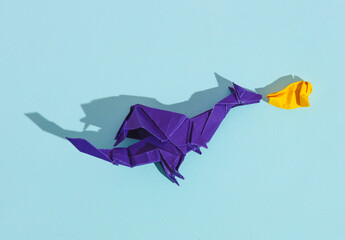 Origami dragon with flames from the mouth on a blue background