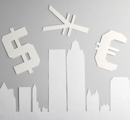 Paper cut city with skyscrapers and different currency signs on gray background