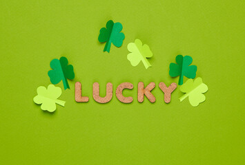 St.Patrick 's Day. Word lucky with clover leaves on a green background