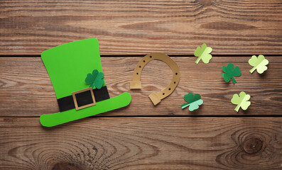 St.Patrick 's Day. Paper leprechaun hat with clover leaves and horseshoe on wooden background....