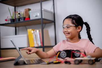 Asian students learn at home by coding robot cars and electronic board cables in STEM, STEAM,...