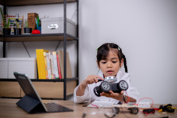 Asian students learn at home by coding robot cars and electronic board cables in STEM, STEAM, mathematics engineering science technology computer code in robotics for kids' concepts.
