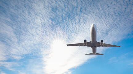 Obraz premium White passenger airplane flying in the sky amazing clouds in the background - Travel by air transport