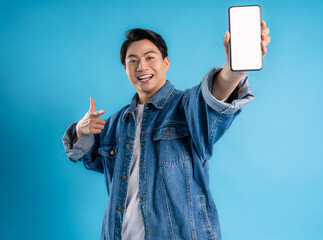 Young asian man using phone on a blue background