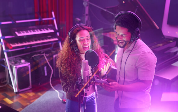 Technology, singing or musician people on neon studio microphone or music lyrics app in night recording. Singers, collaboration or artists on tablet production, voice media or light sound performance