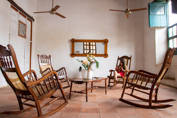 brunette woman sitting in white room with high ceilings