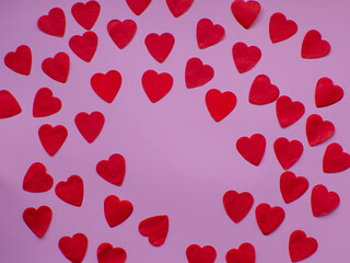 Red heart paper on pastel pink background, top view with copy space. Greeting card. Valentines day holiday concept. Flat lay with a lot of tiny heart-shaped papers with space for text. February 14th. 