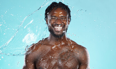 Fototapeta na wymiar Water splash, beauty and black man isolated on blue background for face cleaning, body shower and skincare. Strong, muscle and happy model or person facial glow in studio headshot washing or hygiene