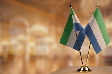 Small flags of the Sierra Leone on an abstract blurry background