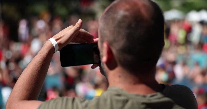 Smartphone in hand of person at summer concert or rally