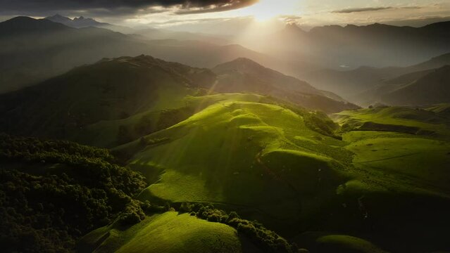 Green mountains in the evening sunlight. Aerial drone view. Summer landscape. Aktoprak pass in North Caucasus, Russia.
