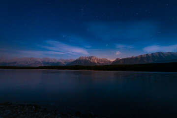 Fototapeta na wymiar Nighttime starscape of a mountain lake in the Canadian Rocky Mountains, Kananaskis Country Alberta, Canada